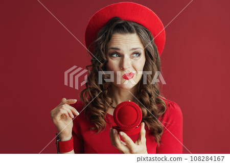 unhappy elegant woman in dress and beret against background unhappy elegant woman in dress and beret against background 108284167