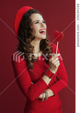 smiling elegant woman in red dress and beret smiling elegant woman in red dress and beret 108284168