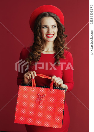 happy stylish woman in dress and beret with shopping bags 108284173