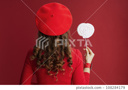 Seen from behind woman in red dress and beret Seen from behind woman in red dress and beret 108284179