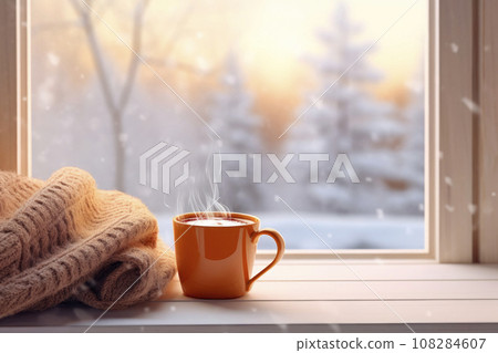 mug of hot coffee and woolen knitting on windowsill against snow landscape from outside mug of hot coffee and woolen knitting on windowsill against snow landscape from outside 108284607