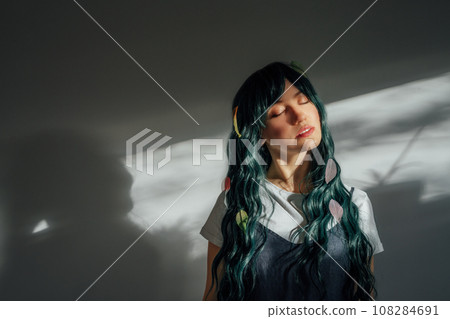 Beautiful tender woman with long dark green hair and multicolored skeleton leaves in ray of sunset light. Attractive fantasy girl, Young elven princess style. A gentle image. Autumn, fall concept. Beautiful tender woman with long dark green hair and multicolored skeleton leaves in ray of sunset light. Attractive fantasy girl, Young elven princess style. A gentle image. Autumn, fall concept. 108284691