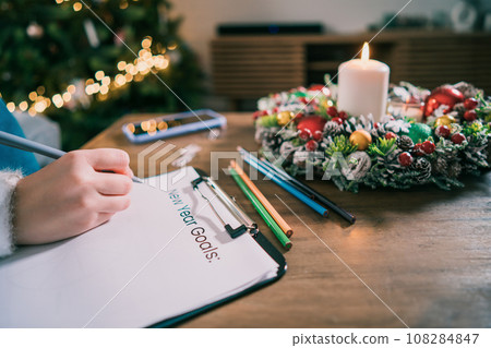 Female hand writing New year's goals on note paper in new year day. New year resolutions list. Goals, resolutions, plans, action, checklist concept. New Year template, copy space. Selective focus 108284847