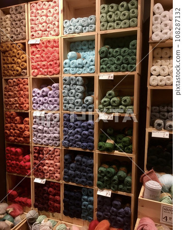 A shelf lined with colorful knitted yarn piles 108287132