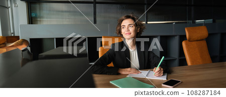 Portrait of saleswoman, ceo manager in office, working on project, writing down notes in documents 108287184