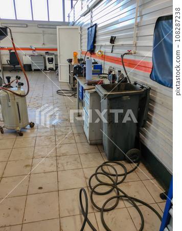 Tools for car repair are laid out in a car repair shop. Empty car repair workshop. Workshop concept with tools without people. 108287238