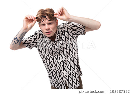 European young man with golden hair and a tattoo on his arms dressed in a summer black and white 108287552