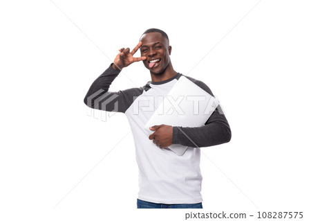 young american man dressed in a black and white sweater holding a gray laptop on a white background 108287575