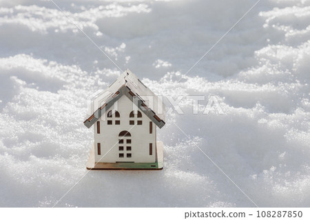 model of house is standing in snow, mock-up, sale of real estate, rent of an apartment or house. model of house is standing in snow, mock-up, sale of real estate, rent of an apartment or house. 108287850