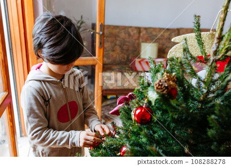high angle view on child in rudolf overall decorating christmas tree high angle view on child in rudolf overall decorating christmas tree 108288278
