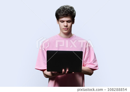 Young male college student using laptop, white studio background 108288854