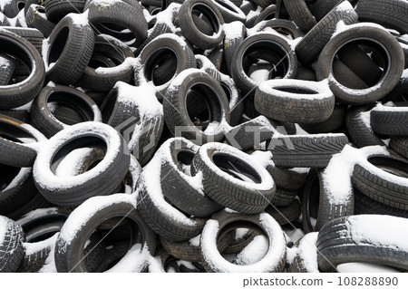 Pile of old tyres covered by snow. Black and white photography. Pile of old tyres covered by snow. Black and white photography. 108288890