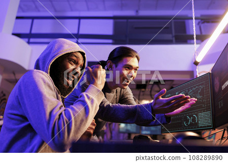 Excited criminals hacking online server database successfully and celebrating with victory gesture. Happy young men getting system hacked message on screen while breaking into website Excited criminals hacking online server database successfully and celebrating with victory gesture. Happy young men getting system hacked message on screen while breaking into website 108289890