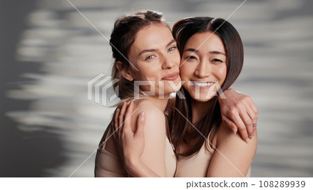 Cheerful beauty models posing on camera for campaign, advertising self acceptance and skincare products. Happy friends with different skintones promoting diversity and body confidence. Cheerful beauty models posing on camera for campaign, advertising self acceptance and skincare products. Happy friends with different skintones promoting diversity and body confidence. 108289939