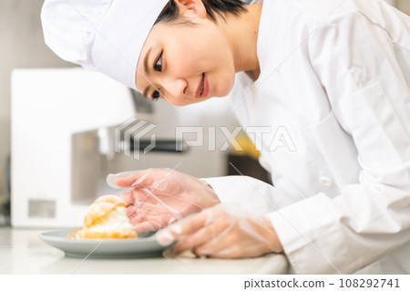 糕點師傅在盤子上提供奶油泡芙 糕點師傅在盤子上提供奶油泡芙 108292741