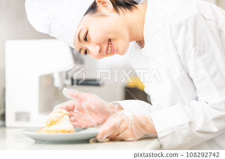 A pastry chef serving cream puffs on a plate A pastry chef serving cream puffs on a plate 108292742