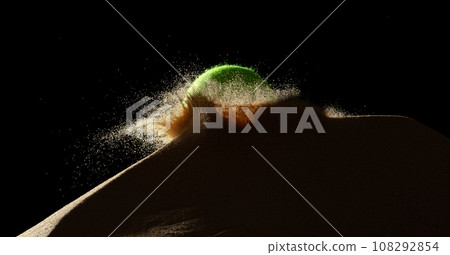 Tennis ball throw hit sand soil and Deep impact on sand hill and splash all over area. Tennis ball hit Sand dune hill over wind storm and blast dust splash over mountain. Black background isolated Tennis ball throw hit sand soil and Deep impact on sand hill and splash all over area. Tennis ball hit Sand dune hill over wind storm and blast dust splash over mountain. Black background isolated 108292854