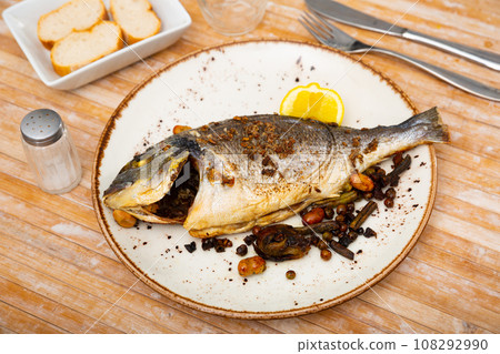 Delicious grilled gilthead bream with lemon 108292990