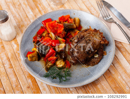 Roasted pork loin served with garnish of baked vegetables Roasted pork loin served with garnish of baked vegetables 108292991