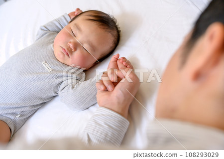 Father putting baby to bed, child holding finger, Ikumen, putting baby to sleep, co-sleeping, grasping reflex, 0-year-old infant 108293029