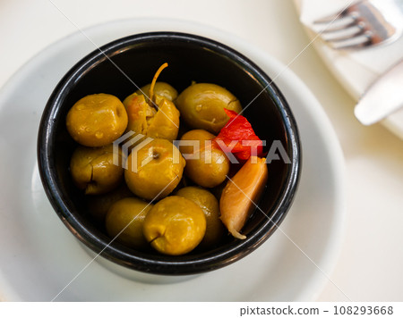Green pitted olives served with garlic on platter 108293668