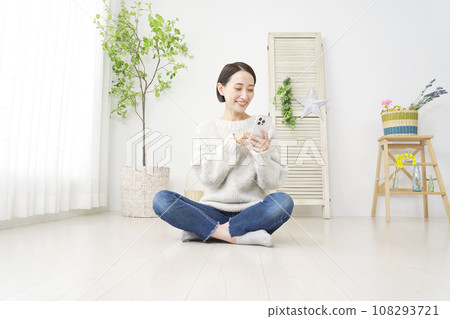 在客廳使用智慧型手機的女性，全身，可用影印空間 108293721