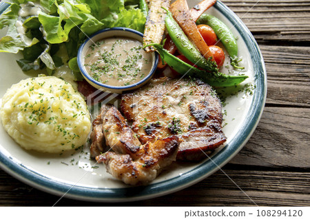 rilled pork steak with Fried vegetables and mashed potatoes close-up on a plate 108294120