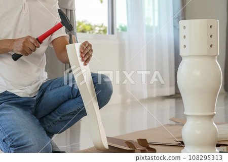 Man assembling furniture at home 108295313