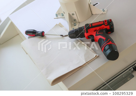 Cordless screwdriver on wood table assembly furniture concept 108295329