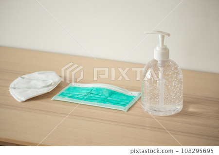 Medical face mask with alcohol sanitizer gel hand wash on wood table for covid-19 Coronavirus prevention concept 108295695