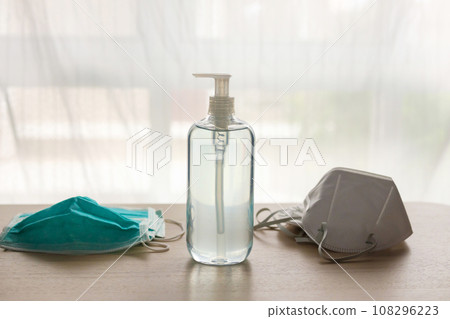 Medical face mask with alcohol sanitizer gel hand wash on wood table for covid-19 Coronavirus prevention concept 108296223