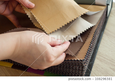 female designer with fabric color samples choosing textile for curtains 108296381