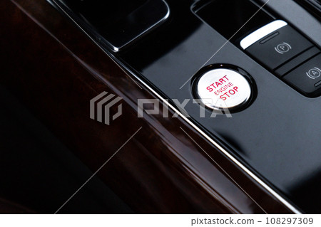 Start stop engine button Interior of modern luxury car. Details of automatic transmission gear shift, multimedia control system, car control panel, Air Vent Red emergency button and dashboard inside Start stop engine button Interior of modern luxury car. Details of automatic transmission gear shift, multimedia control system, car control panel, Air Vent Red emergency button and dashboard inside 108297309