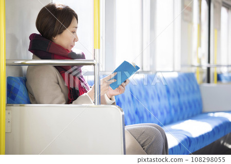 Middle woman sitting on the train and reading Middle woman sitting on the train and reading 108298055