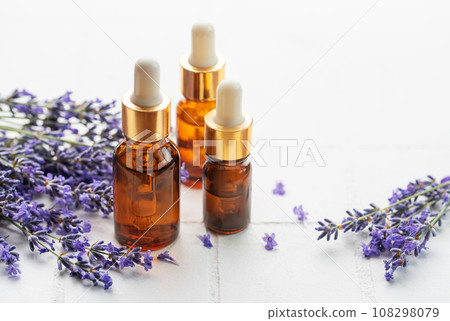 Lavender  natural essential oil and fresh lavender on a white tile background. 108298079
