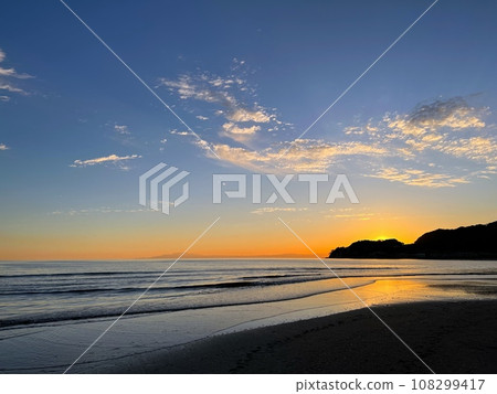 Kamakura seascape, sunset sky and distant view of the Izu Peninsula, sunset on the beach, landscape on the beach, sunset over the sea and surfer between the waves 108299417