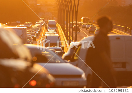 Busy cross over the street with many cars on sunset Busy cross over the street with many cars on sunset 108299581