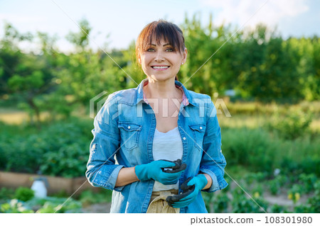 Portrait of woman farmer, nature field with plants vegetables Portrait of woman farmer, nature field with plants vegetables 108301980