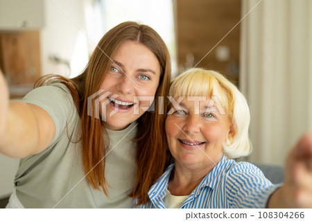 Head shot portrait happy woman with mature mother taking selfie together, Happy senior woman enjoying in daughter's affection on Mother's day. 108304266