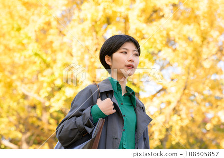 A woman enjoying autumn leaves alone in a park A woman enjoying autumn leaves alone in a park 108305857