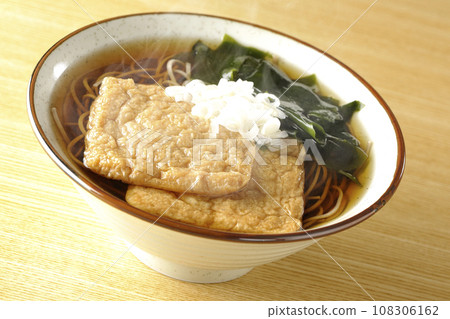 熱狐蕎麥麵配兩塊炸豆腐、裙帶菜和蔥。 熱狐蕎麥麵配兩塊炸豆腐、裙帶菜和蔥。 108306162