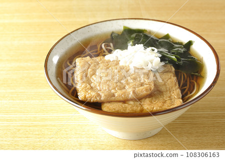 熱狐蕎麥麵配兩塊炸豆腐、裙帶菜和蔥。 熱狐蕎麥麵配兩塊炸豆腐、裙帶菜和蔥。 108306163