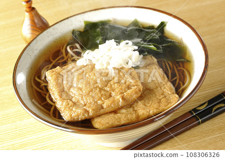 熱狐蕎麥麵配兩塊炸豆腐、裙帶菜和蔥。 熱狐蕎麥麵配兩塊炸豆腐、裙帶菜和蔥。 108306326
