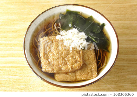 頭頂上的熱騰騰的狐狸蕎麥麵，上面放著兩片炸豆腐、海藻和大蔥。 108306360