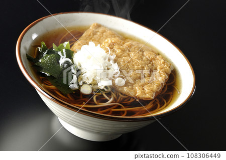 熱狐狸蕎麥麵，上面放著兩片炸豆腐、海藻和大蔥，在黑色背景下拍攝 108306449