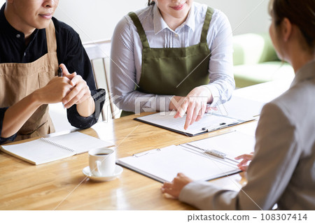 Restaurant manager listening to businesswoman's presentation Restaurant manager listening to businesswoman's presentation 108307414