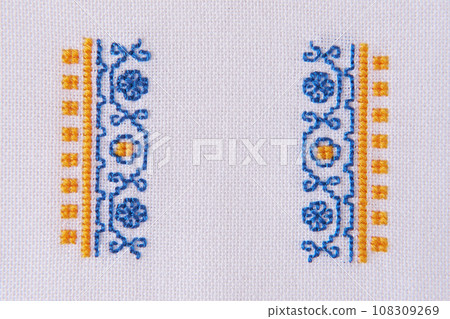 Element of Handmade Embroidery on White Linen by blue and yellow Cotton Threads. Craft Design Element of Handmade Embroidery on White Linen by blue and yellow Cotton Threads. Craft Design 108309269