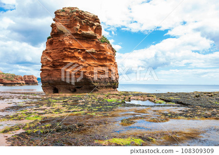 Rock formations in Ladram Bay, United Kingdom. View of the beach and red and orange cliffs and the sea, Jurassic coast, selective focus Rock formations in Ladram Bay, United Kingdom. View of the beach and red and orange cliffs and the sea, Jurassic coast, selective focus 108309309