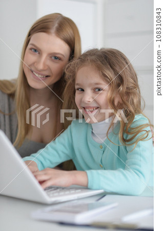 Mother and daughter looking at laptop computer 108310843
