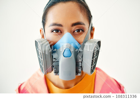 Close up portrait of young woman in protective respirator mask looking to camera over white background Close up portrait of young woman in protective respirator mask looking to camera over white background 108311336